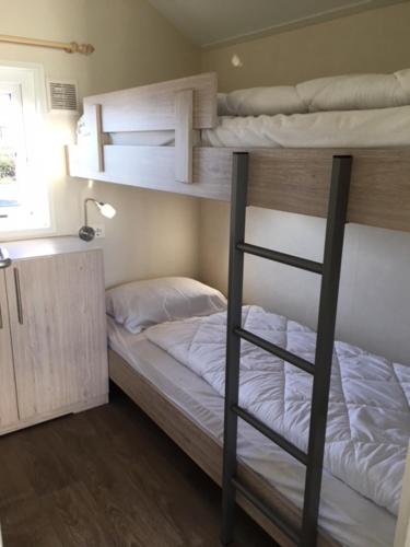 a bedroom with two bunk beds in a room at Camping Oase, Zanddijk 75 in Julianadorp