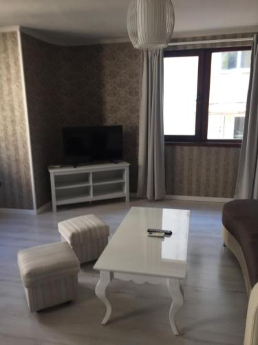 a living room with a coffee table and a tv at Family Hotel Argo in Varna City