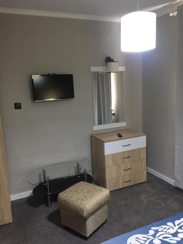 a bedroom with a dresser and a tv on the wall at Family Hotel Argo in Varna City