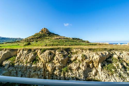 a hill with crops on top of a mountain at Hillock Residence Apartments in Marsalforn