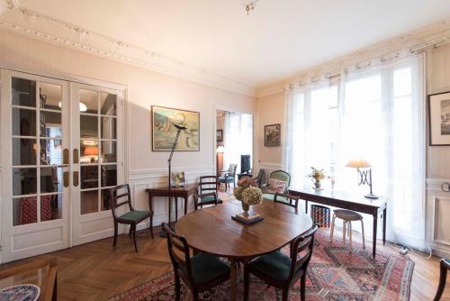 a dining room with a table and chairs at Veeve - Tranquility by Le Jardin du Luxembourg in Paris