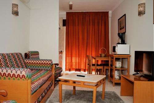 a living room with a couch and a coffee table at Apartamentos Turisticos Lindomar in Armação de Pêra
