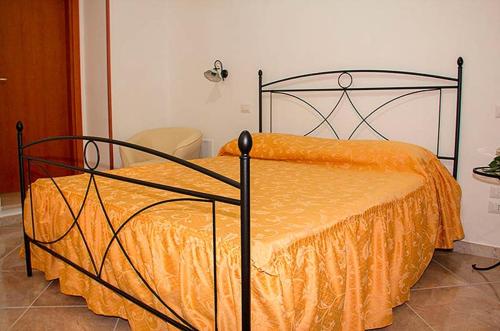 a bed with an orange comforter in a room at A Pastaiola in Cetara