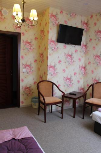 a room with two chairs and a tv on the wall at Viesu nams AMRAI in Ventspils