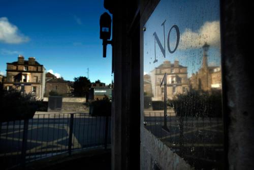 a window with a no sign on the side of a building at Mackays Hotel in Wick