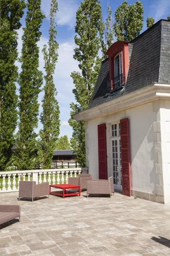 a building with chairs and a table in front of it at Le domaine de barbizon in Saint-Martin-en-Bière