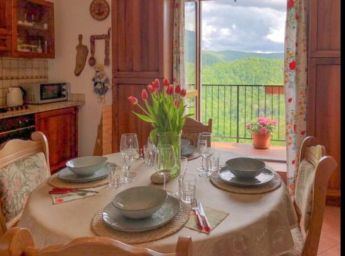 einen Tisch mit Tellern und Gläsern und eine Vase Blumen in der Unterkunft House For Relaxing Holiday in Casasco Intelvi
