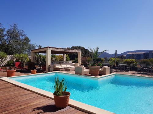 a swimming pool with a gazebo next to at Hotel Le Tilbury in Porto-Vecchio