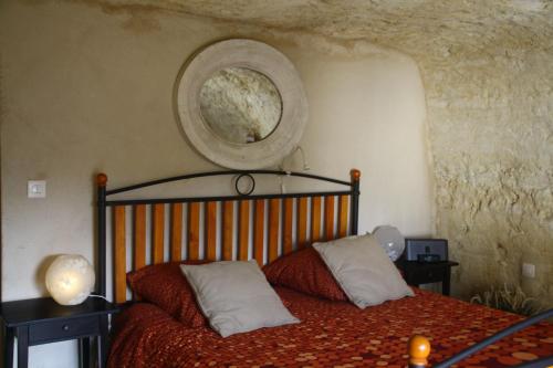 a bedroom with a bed and a round mirror on the wall at Clos Mariotte in Vouvray