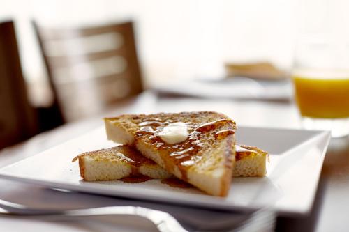 a plate with a piece of bread with butter on it at Hyatt Place Warwick/Providence Airport in Warwick