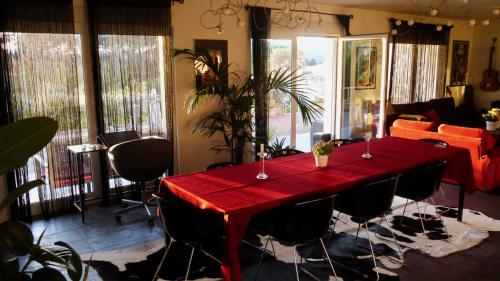 a red table in a room with chairs and a couch at Quinta das Leiras - Rubiães in Paredes de Coura