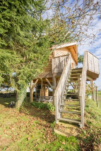 a tree house with stairs leading up to it at Les Jardins de Coët-Kra in Plaudren
