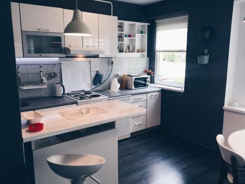 a kitchen with white cabinets and a stove top oven at Apartment Amra in Visoko