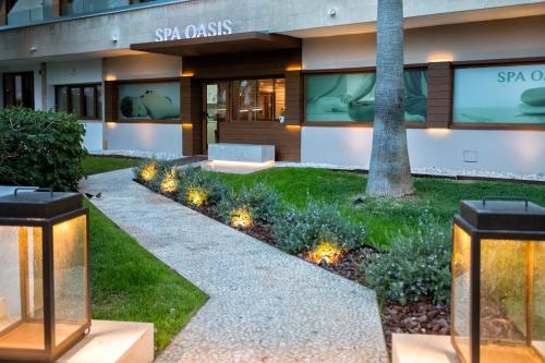a garden with lights in front of a building at Hotel Son Caliu Spa Oasis in Palmanova