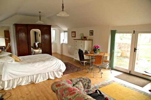 East Knoyle的住宿－Cools Farm B&B + Cottages，卧室配有一张床和一张桌子及椅子