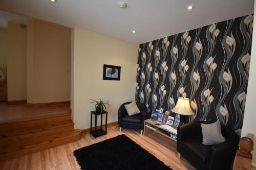 a living room with a black and white patterned wall at Aaranmore Lodge Guest House in Portrush