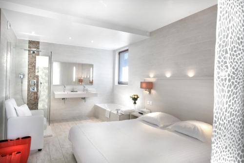 1 dormitorio con cama blanca y baño en Seventeen Hotel, en Valbonne