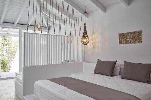 biała sypialnia z łóżkiem i żyrandolem w obiekcie Mr and Mrs White Corfu Couples Retreat Adults Only w Acharavi