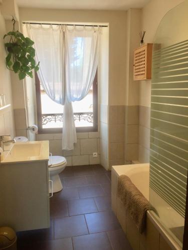 une salle de bain avec baignoire et toilettes et une fenêtre dans l'établissement Chaillac Bed & Breakfast, à Chaillac