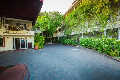 
a walkway leading to a building with trees at Altamont Court Hotel in Kingston
