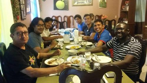 a group of men sitting at a table eating food at La Belle Maison Milot in Samson