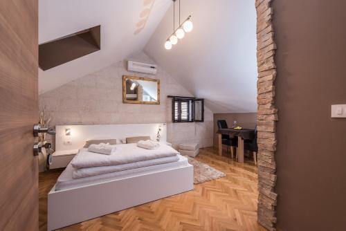 um quarto com uma cama branca num sótão em Apartments Donat em Zadar