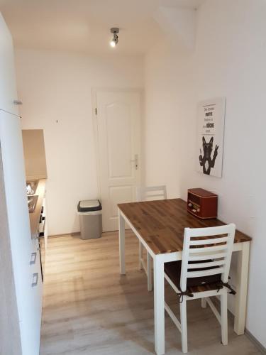 a dining room with a wooden table and white chairs at Hanse Hotel Buxtehude in Buxtehude
