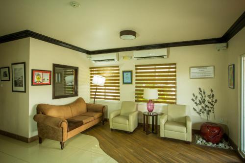 a living room with a couch and two chairs at Altamont Court Hotel in Kingston
