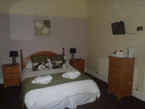 a bedroom with a bed with pillows and a dresser at Gillygate Guest House in York