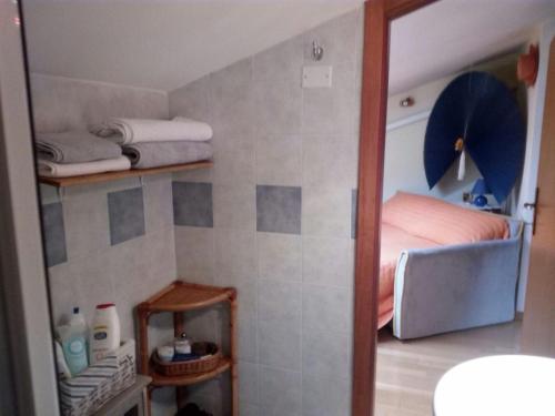 a small bathroom with a bed and towels on shelves at La mansarda di Daniela in Montepulciano Stazione