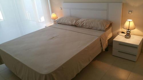 ベニドルムにあるapartameno con panoramicas vistasのベッドルーム(白い大型ベッド、ランプ2つ付)