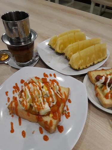 three plates of food on a wooden table at Arya Inn in Pematangsiantar