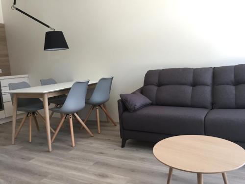 uma sala de estar com um sofá, uma mesa e cadeiras em Memel home old city apartment em Klaipėda