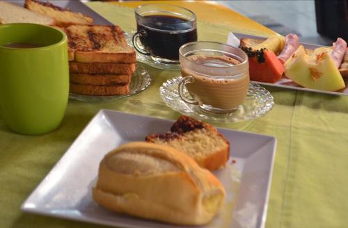 a table with a plate of bread and a cup of coffee at Cabo Frio Fun Hostel in Cabo Frio