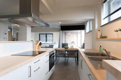 a kitchen with white cabinets and a sink and a counter at Raveel Lofts in Deinze