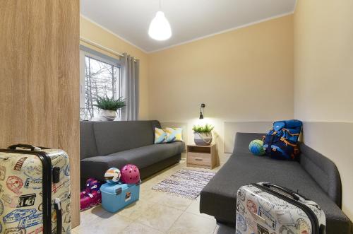 a living room with a couch and two suitcases at Arenda Apartamenty&Domki całoroczne in Sieraków