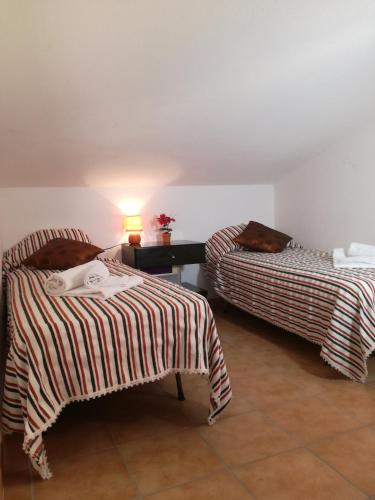 una camera con due letti e un tavolo con una lampada di Las Dos Islas a Castelsardo