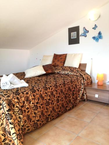 a bedroom with a bed with a brown comforter at Casa VeroSol in Castelsardo