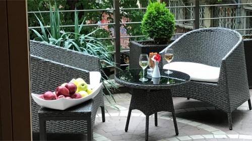 a table and chairs with a bowl of fruit and wine glasses at Art 'Otel in Sofia