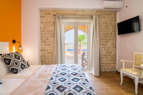 a bedroom with a bed and a door to a patio at Aristidis country villa-anesis in Kamilari