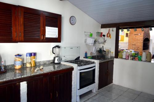 a kitchen with wooden cabinets and a stove top oven at Cabo Frio Fun Hostel in Cabo Frio