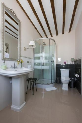 a bathroom with a sink and a shower and a toilet at La Casa de la Vieja - Rustic & Charming Appartments in Belmonte