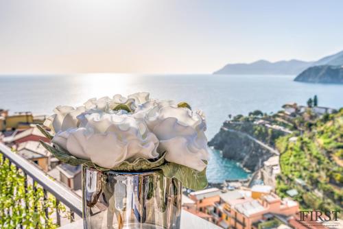 a vase filled with white flowers sitting on a balcony at Il Sogno di Manarola by The First in Manarola