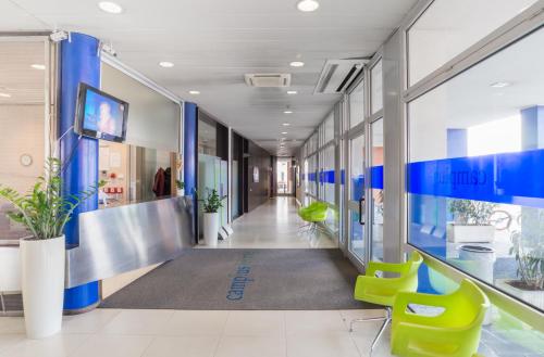 an office with a hallway with blue and green chairs at Camplus Lambrate Casa per Ferie in Milan