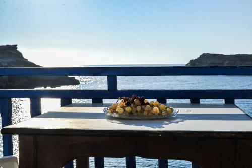 a bowl of fruit sitting on a table near the water at Zorbas Studios in Lefkos Karpathou