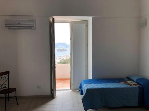 a bedroom with a bed and a door to a balcony at Casa GARY in Ponza