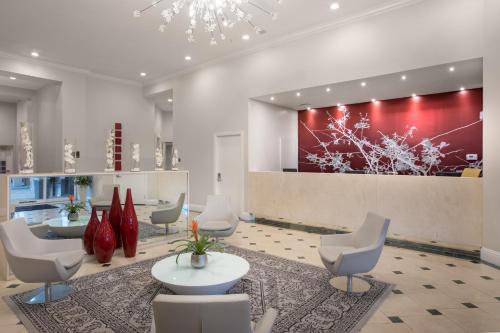 a lobby with chairs and tables and a red wall at The Point Hotel & Suites Universal in Orlando