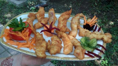 un plato de comida con palitos de pescado y verduras en Hotel Bulaq, en Turist