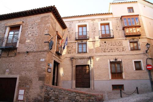 a large brick building with windows and a door at Hotel Santa Isabel in Toledo