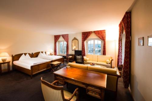 a hotel room with a bedroom with a bed and a desk at Hotel Stadthaus in Burgdorf